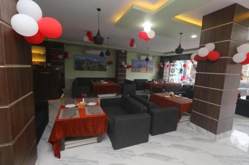 a restaurant with couches and tables and red and white balloons at Hotel Gajur Palace in Itahari