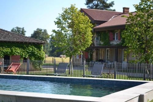 a house with a swimming pool in front of a house at La Ferme du Domaine de Bassol – Piscine & Billard in Mézériat