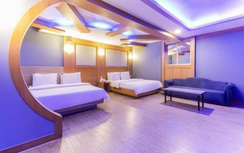 a hotel room with two beds and a couch at Hotel Head-One in Uijeongbu