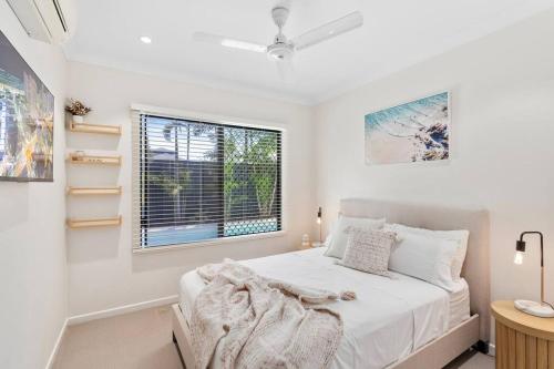 een witte slaapkamer met een bed en een raam bij Solace on Castleton - Modern, Spacious, Private in Smithfield