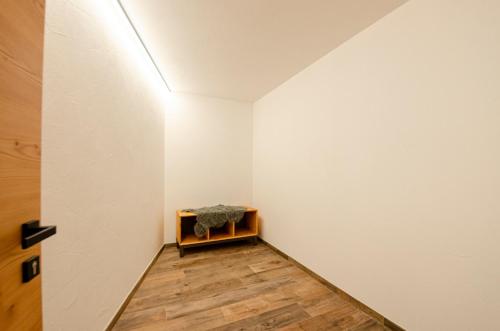 a room with white walls and a wooden floor at Mason La Zondra in Vigo di Fassa
