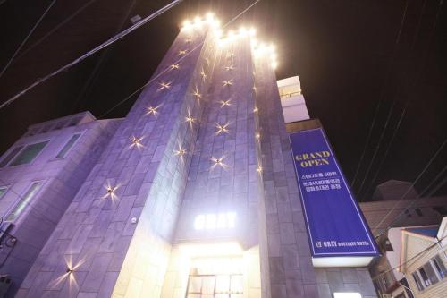 a tall building with lights on it at night at Tongyeong Gray Hotel in Tongyeong
