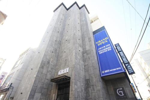 a tall building with a sign on the side of it at Tongyeong Gray Hotel in Tongyeong