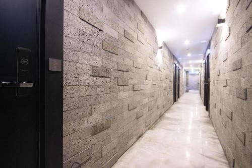 a hallway with a brick wall and a hallway with a door at Tongyeong Gray Hotel in Tongyeong