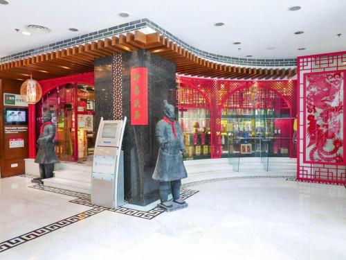 a store with two statues in the middle of a building at Shaanxi Business Hotel in Shanghai