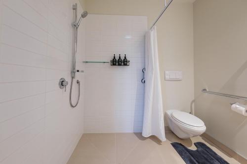 a white bathroom with a toilet and a shower at Amuri Estate Luxury Lodge in Hanmer Springs