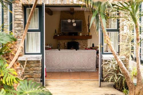 a living room with a fireplace and a tv on a wall at Luxury House on Seafront in Curryglass