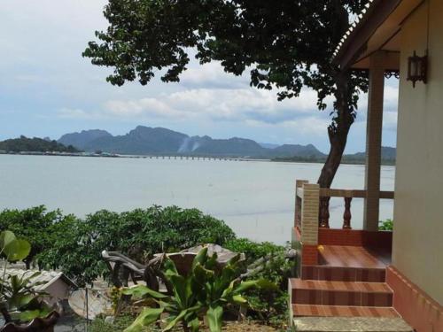 a house with a porch with a view of the water at Wanghin Bungalow in Surat Thani