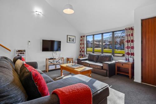 a living room with a couch and a tv at Lake Villa 463 in Hanmer Springs