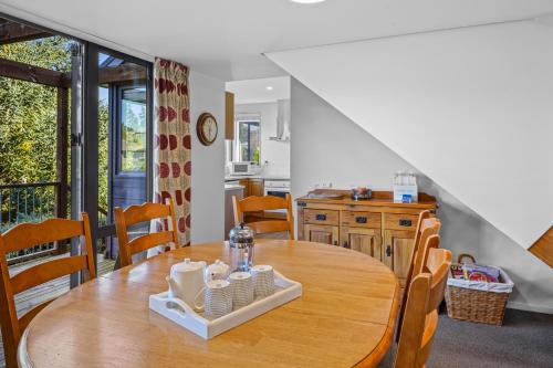 a kitchen and dining room with a wooden table and chairs at Lake Villa 463 in Hanmer Springs