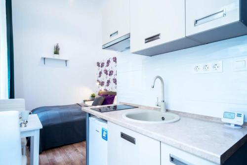 a bathroom with a sink and a bed in a room at Modern Intimate Studio in the center in Budapest