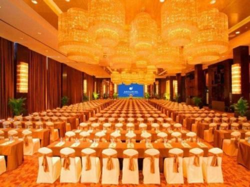 a large banquet hall with rows of tables and chairs at New Century Shaoxing Grand Hotel in Shaoxing