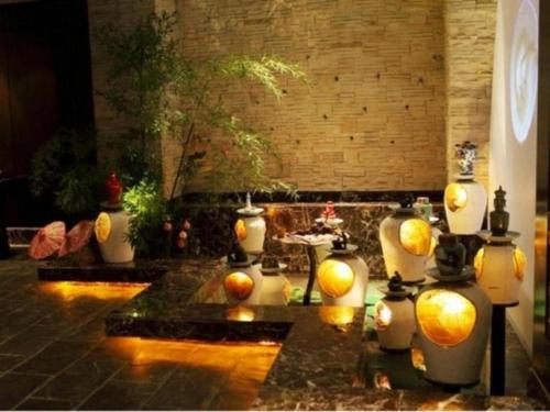a group of vases with oranges in a room at New Century Shaoxing Grand Hotel in Shaoxing