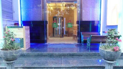 a front door of a building with two potted plants at An Hotel Jakarta in Jakarta