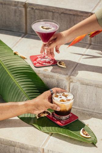 a person holding a drink on a tray with two drinks at W15 Weligama in Weligama