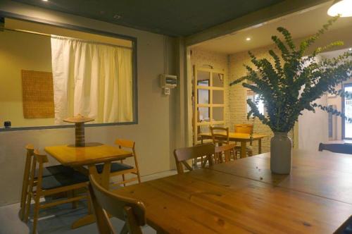 a dining room with a wooden table and chairs at THE GOOSE HOUSE UBON in Ubon Ratchathani