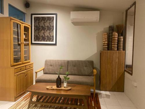 a living room with a couch and a table at THE GOOSE HOUSE UBON in Ubon Ratchathani