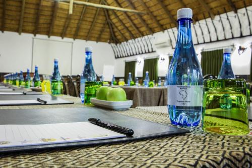 a table with a bottle of water and a pen at Kedar Heritage Lodge, Conference Centre & Spa in Phokeng