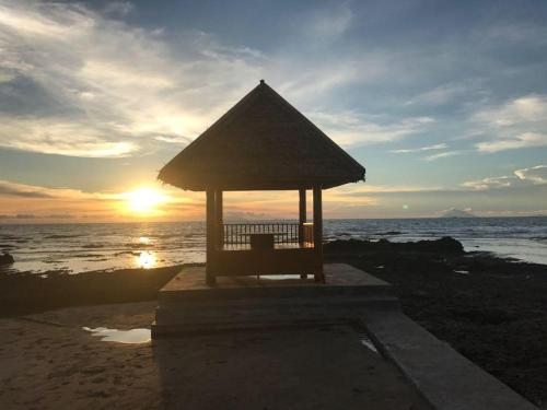 a bench on the beach with the sunset in the background at Double G Resort Anyer in Carita