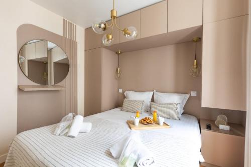 - une chambre avec un lit et un plateau de nourriture dans l'établissement Bluestay 159 - Charmant appartement à Paris 2, à Paris