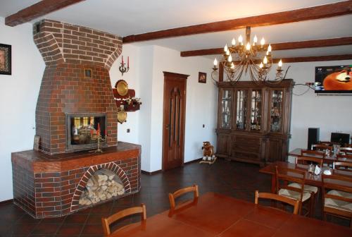 a living room with a brick fireplace and a dining room at Kraevyd Hotel in Yaremche
