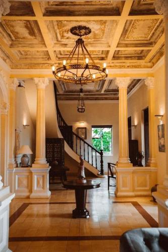 a large room with a staircase and a chandelier at Le Relais de Chhlong in Kratie