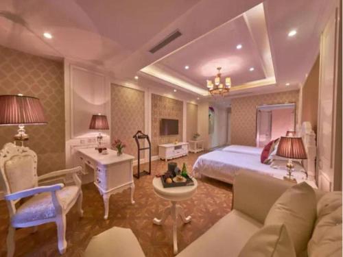 a bedroom with a bed and a desk and a couch at New century Manju Select Hotel Hongqiao Hub National Exhibition Center in Shanghai