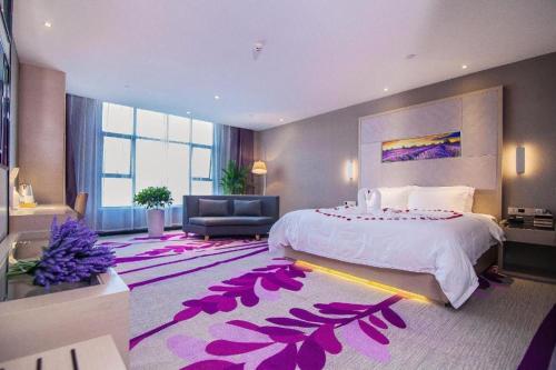 - une chambre avec un grand lit et un tapis violet dans l'établissement Lavande Hotel Jinzhou Gong'an RT-Mart Chinese Medicine Hospital, à Gong'an
