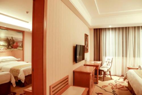 a hotel room with two beds and a television at Vienna Classic Hotel Qingdao Huangdao in Huangdao
