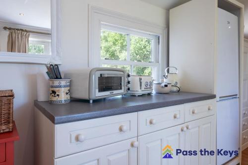 a kitchen counter with a microwave and a window at Charming Countryside Annexe near Oxford Perfect Getaway with Scenic Views in Lewknor