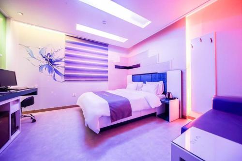 a bedroom with a bed and a desk and a television at Cats Hotel in Changnyeong
