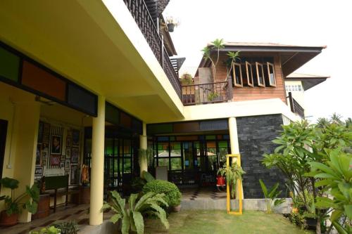 a building with a porch and a balcony with plants at River Jam Amphawa in Amphawa