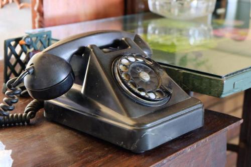 an old fashioned telephone sitting on top of a table at River Jam Amphawa in Amphawa