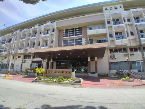 a large building with a sign in front of it at Subic Grand Harbour Hotel Subic Bay in Olongapo