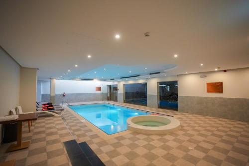 a bathroom with a swimming pool with a toilet in it at Snood Al Narjis Hotel in Riyadh