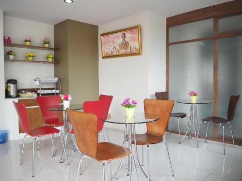 a dining room with red chairs and a table at Regent Room Hotel in Suratthani