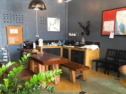 a restaurant with a table and benches in a room at Sritrang Hotel in Trang