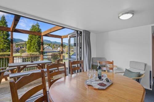 a dining room with a table with wine glasses on it at *** LAKE VILLA 465 *** in Hanmer Springs
