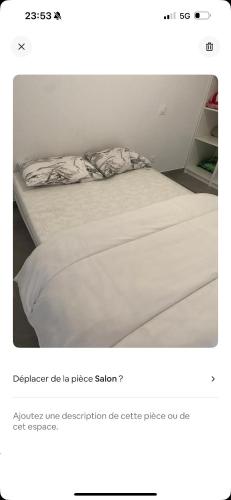 Ce lit se trouve dans un dortoir doté d'un couvre-lit blanc. dans l'établissement Résidence haut standing, à Nice