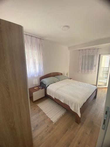 a bedroom with a bed and a window at Apartmani Kostić 