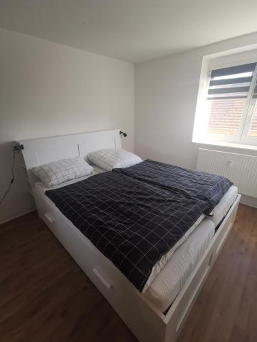 a bed in a white bedroom with a window at Monteursunterkunft in Senftenberg in Sedlitz