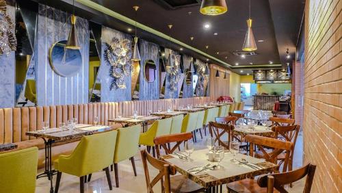 a row of tables in a restaurant with yellow chairs at de BAGHRAF By Amithya in Sumenep