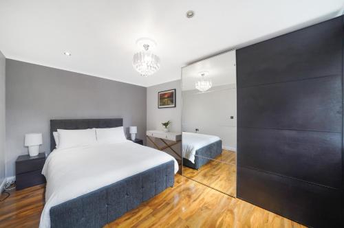 a bedroom with a large bed and a bathroom at A beautiful stylish 2 Bedroom Apartment -City of London in London