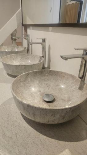 two sinks in a bathroom with two faucets at Neighbor Hostel in Haad Rin