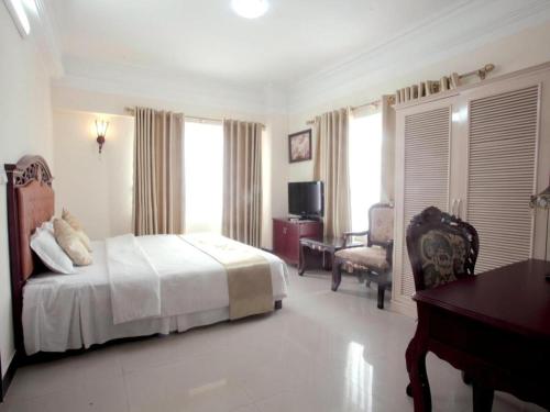 une chambre avec un lit, un bureau et une chaise dans l'établissement Classic Hoang Long Hotel, à Hai Phong