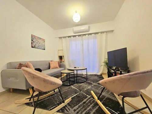 a living room with a couch and a tv at Elysia Park Apartments in Paphos City
