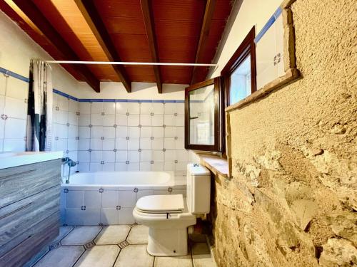 a bathroom with a toilet and a bath tub at Casa rural exclusiva con vista al mar en Calpe in Empedrola