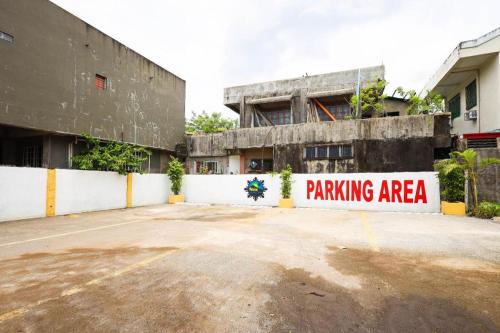 a parking area sign in front of a building at Mayon Backpackers Hostel in Legazpi