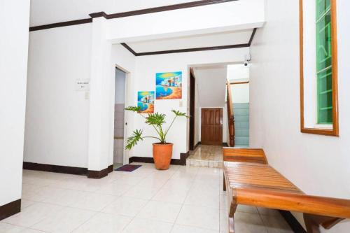 a wooden bench in a hallway with a plant at Mayon Backpackers Hostel in Legazpi
