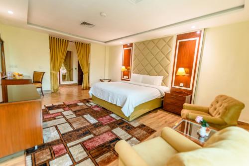 a hotel room with a bed and a living room at Hotel One Faisalabad in Faisalabad